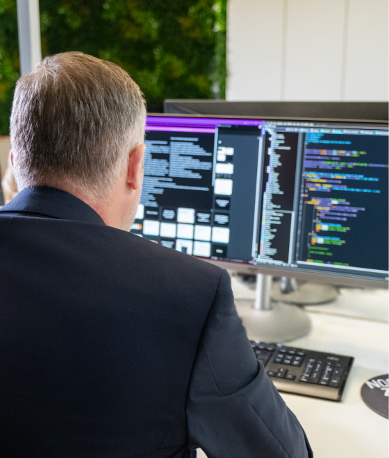 SUNZINET expert sitting at on a computer coding