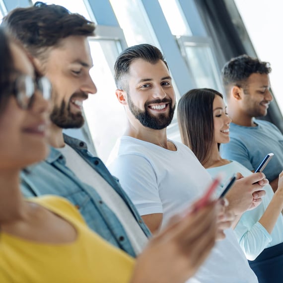 Several people, including women and men, holding smartphones | Intranet Implementation with SUNZINET