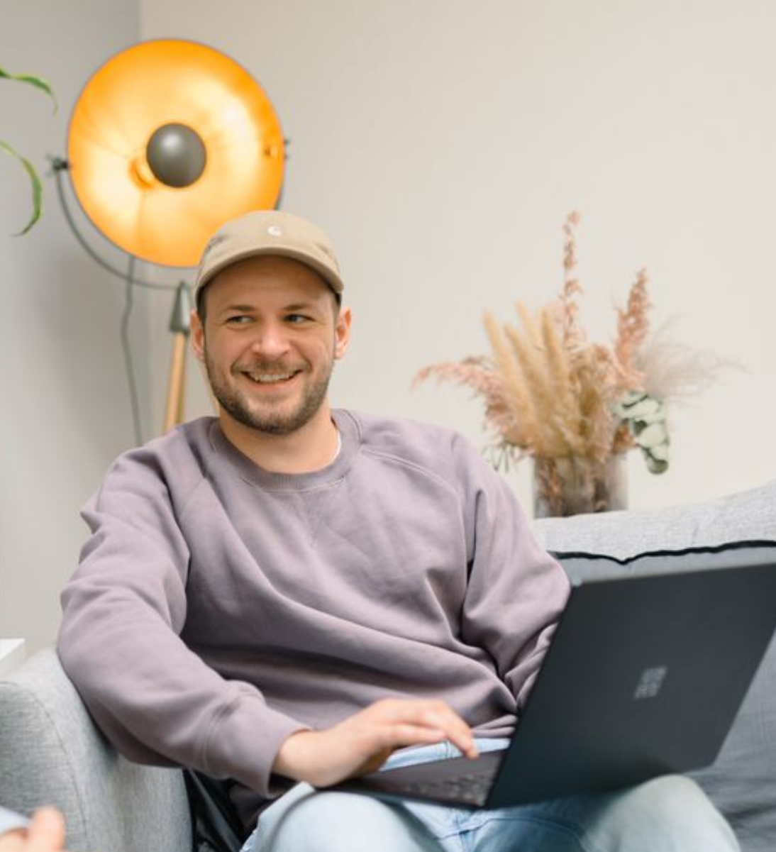 1 Person sitz mit Laptop auf einem Sofa bei full service digitalagentur SUNZINET