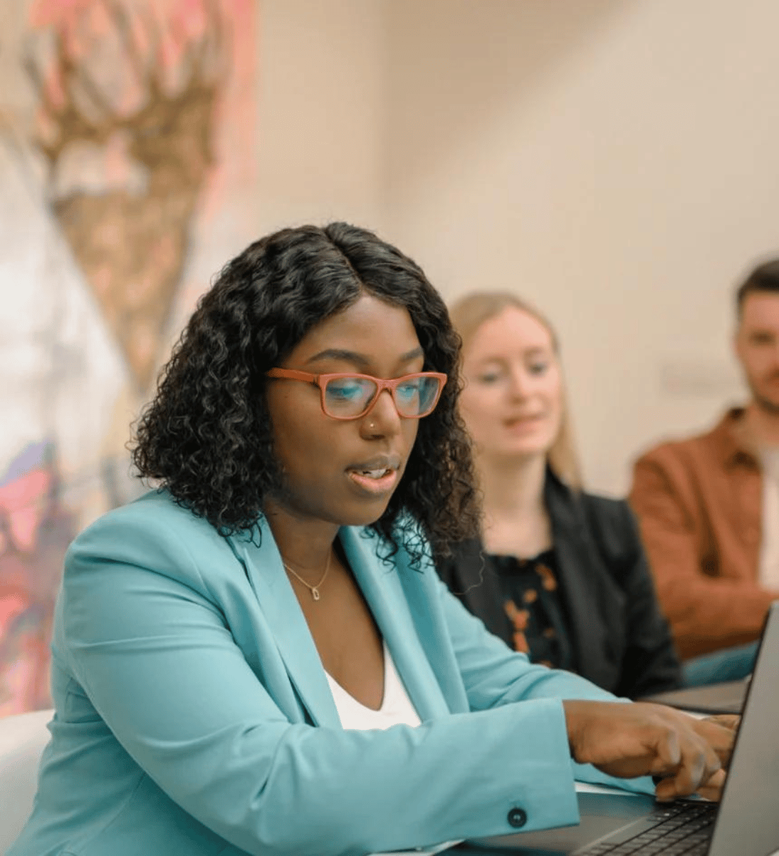 Woman with blazer shows something on her computer - Headless CMS Website development Agency SUNZINET