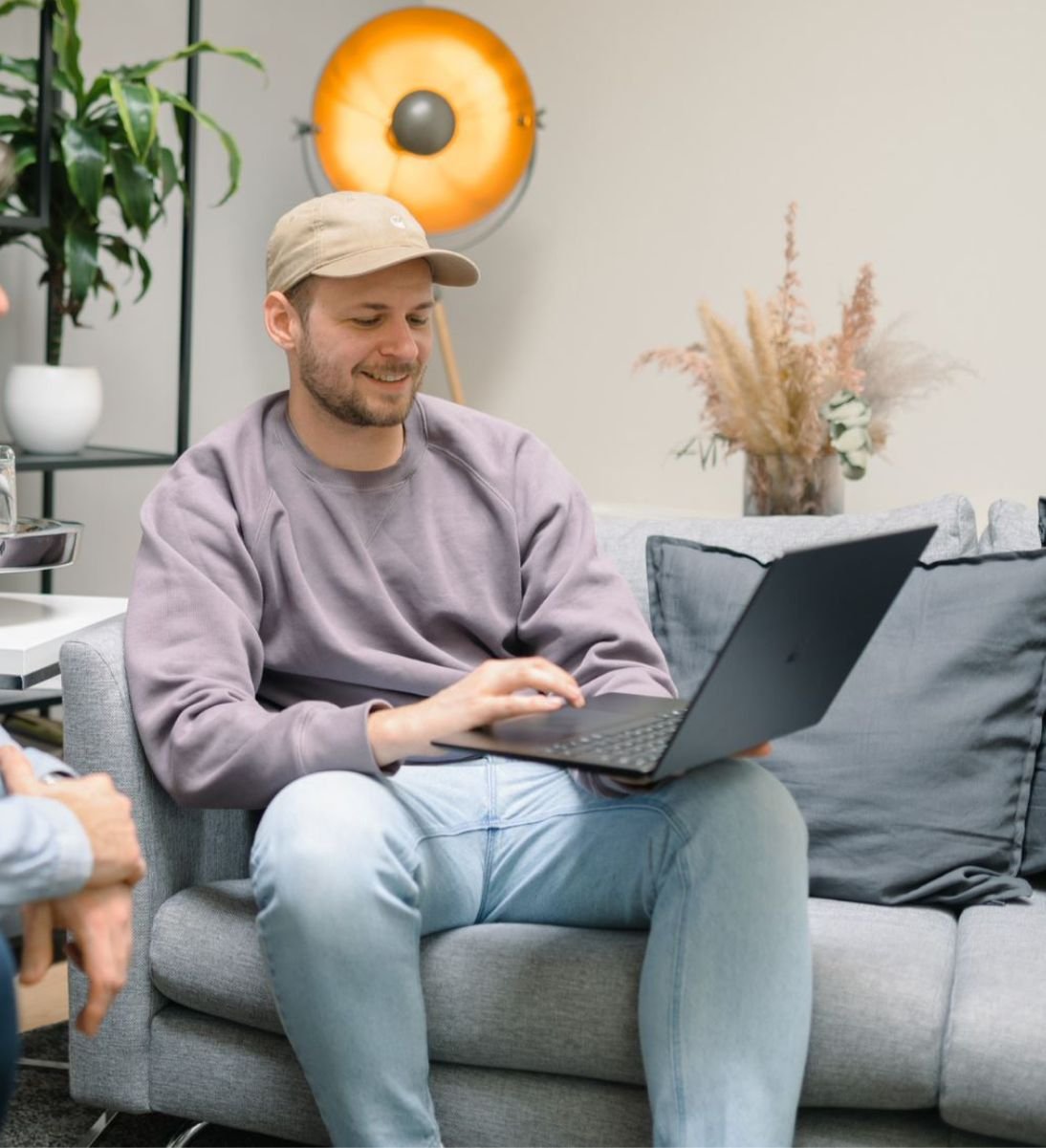 Online marketplace advice - man sits in front of his computer and shows something smiles