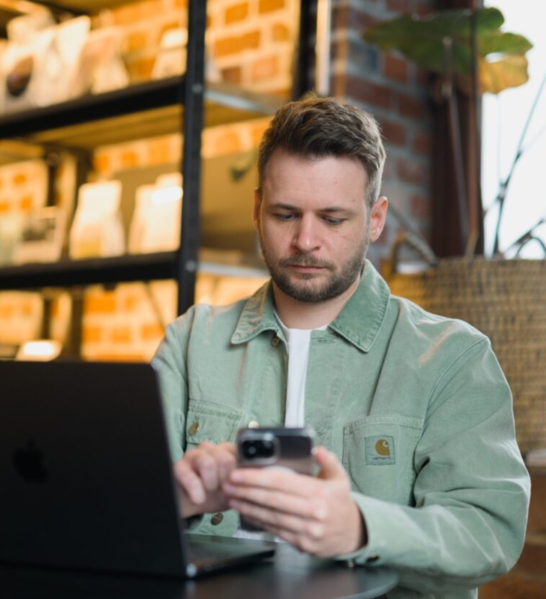 Mann schaut auf sein Handy und recherchiert