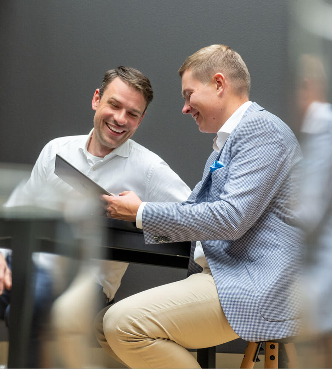 Product and service innovation Header | Two men looking cheerfully at a laptop