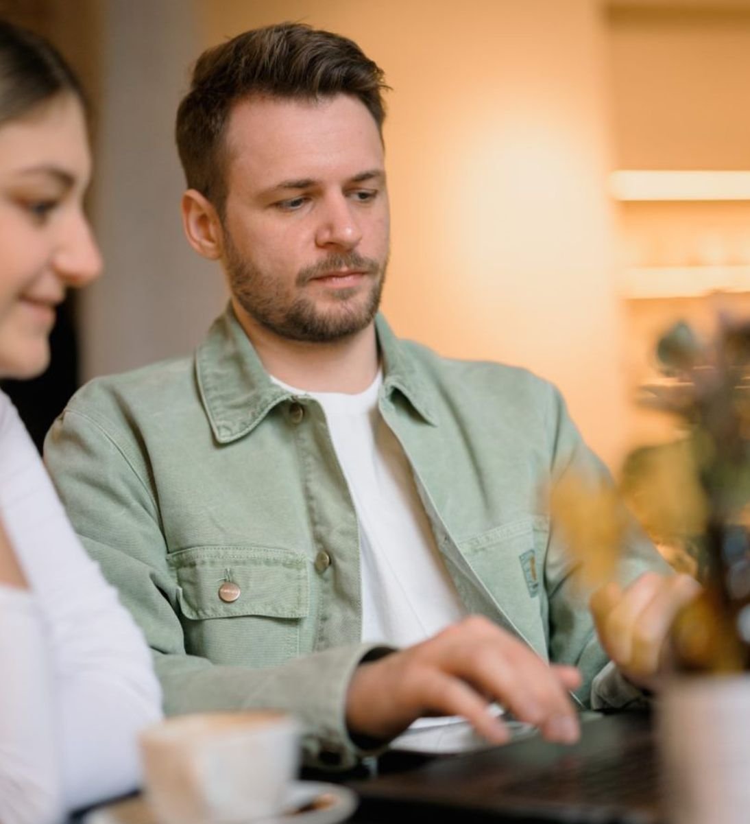 Social Ads Agentur - Mann sitzt vor seinem Computer und zeigt was einer anderen Person