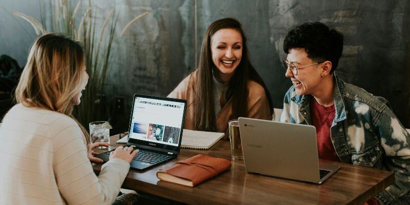 Team arbeitet zusammen an Laptop als Symbolbild für Storyblok Partnerschaft