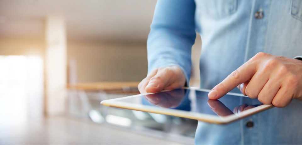 Jemand hält ein Tablet in der Hand und tippt darauf_Digitalagentur für Dienstleister SUNZINET