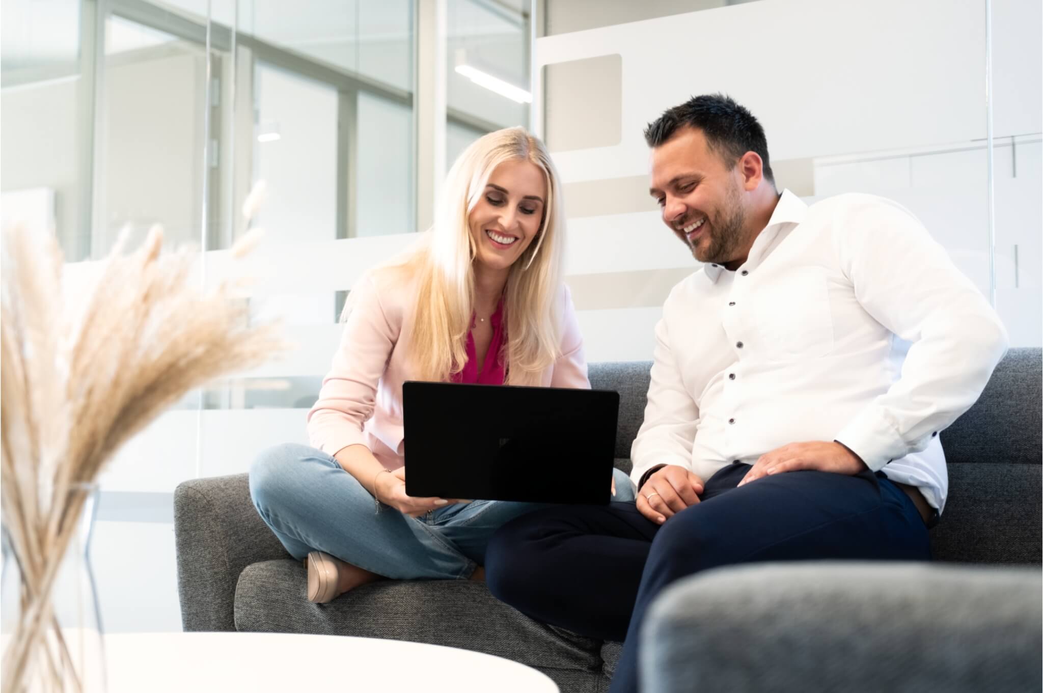 Mann-und-Frau-arbeiten-am-Laptop-lachen