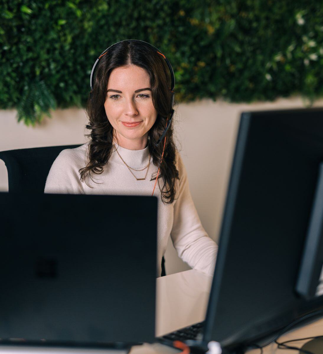 Frau arbeitet mit Headset an Computer | Loyalty Management mit SUNZINET