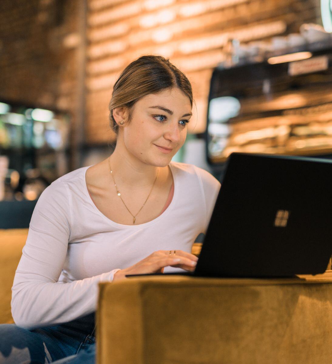 Frau tippt etwas am Laptop | Loyalty Management mit SUNZINET