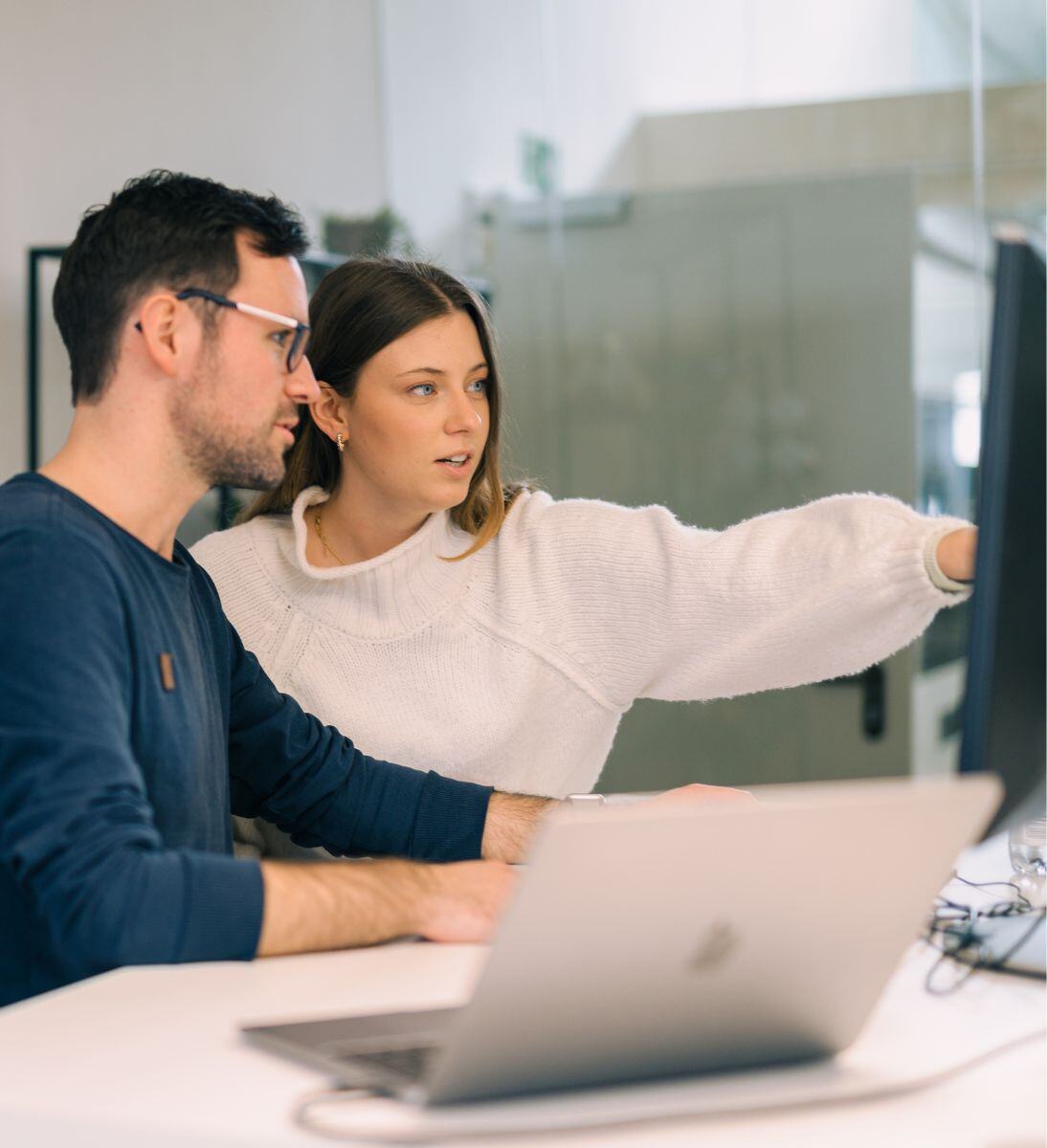 Mann und Frau diskutieren Arbeit am Bildschirm - CRM-Implementierung mit SUNZINET